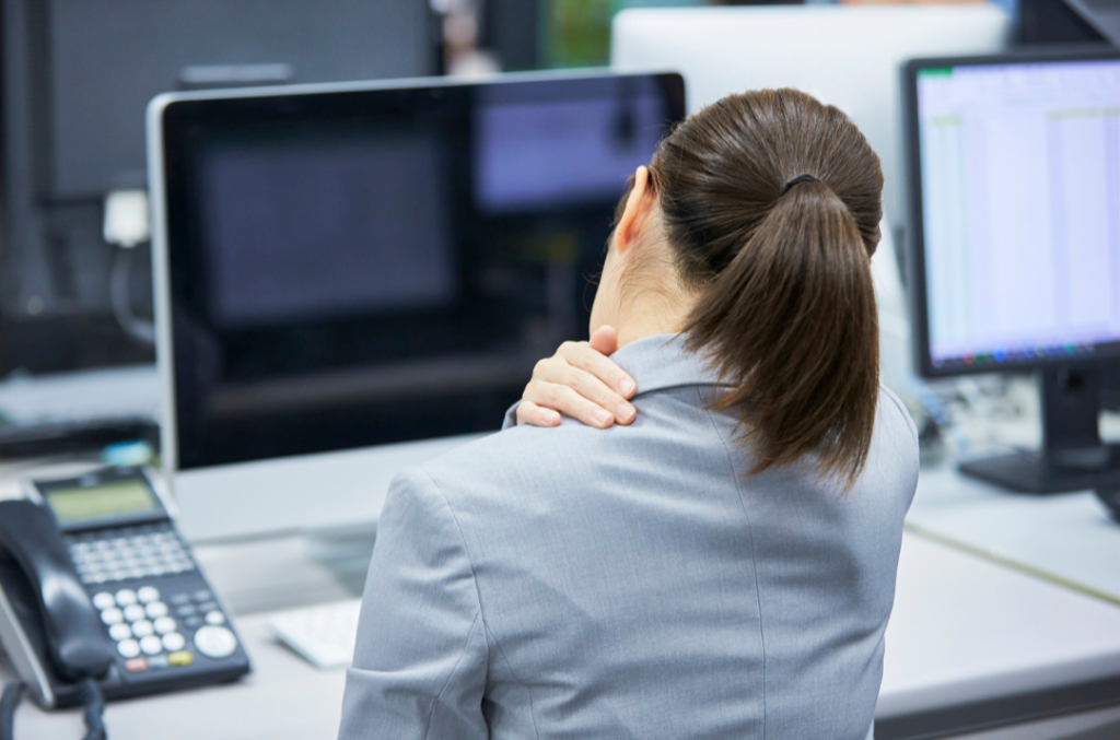 Lady sitting at desk with shoulder pain